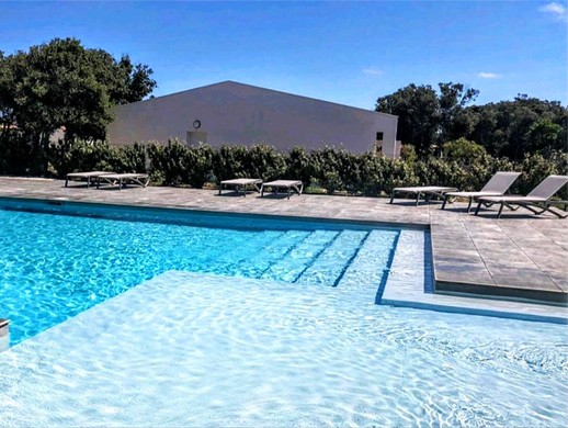 Grande piscine collective de la Villa Casa, avec chaises longues et tout le confort attendu d'une résidence de standing.